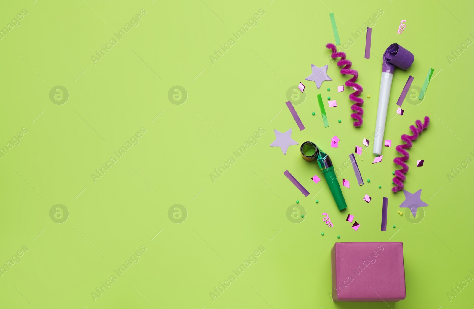 Photo of Flat lay composition with party items and box on light green background, space for text