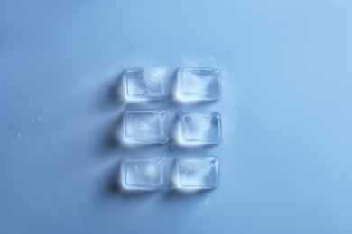 Ice cubes on color background, top view