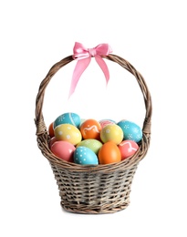 Photo of Wicker basket with painted Easter eggs on white background