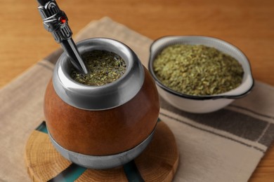 Calabash with mate tea and bombilla on wooden table, closeup