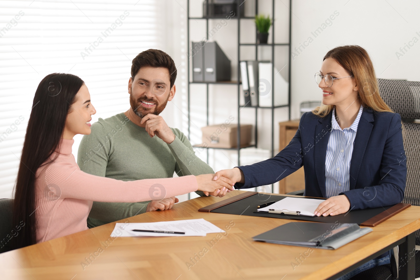 Photo of Lawyer shaking hands with clients in office