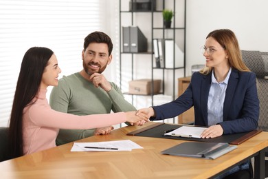 Lawyer shaking hands with clients in office