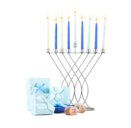 Photo of Hanukkah celebration. Menorah with candles, wooden dreidels and gift boxes isolated on white