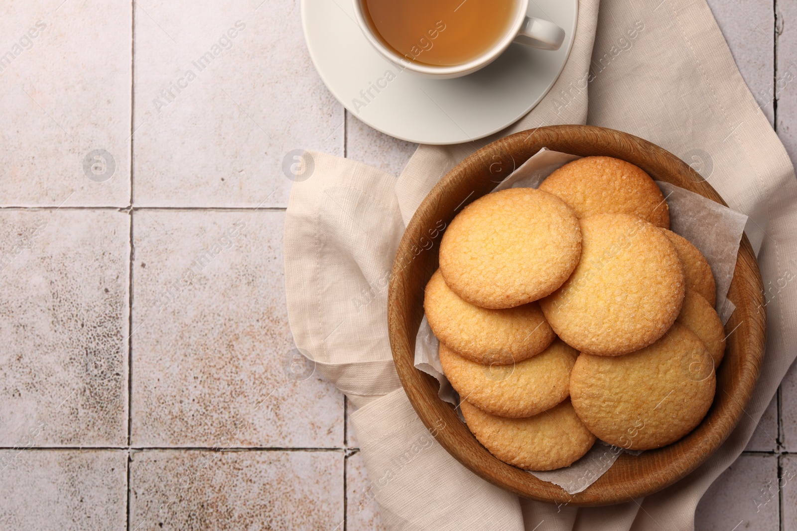Photo of Delicious Danish butter cookies and tea on white tiled table, flat lay. Space for text