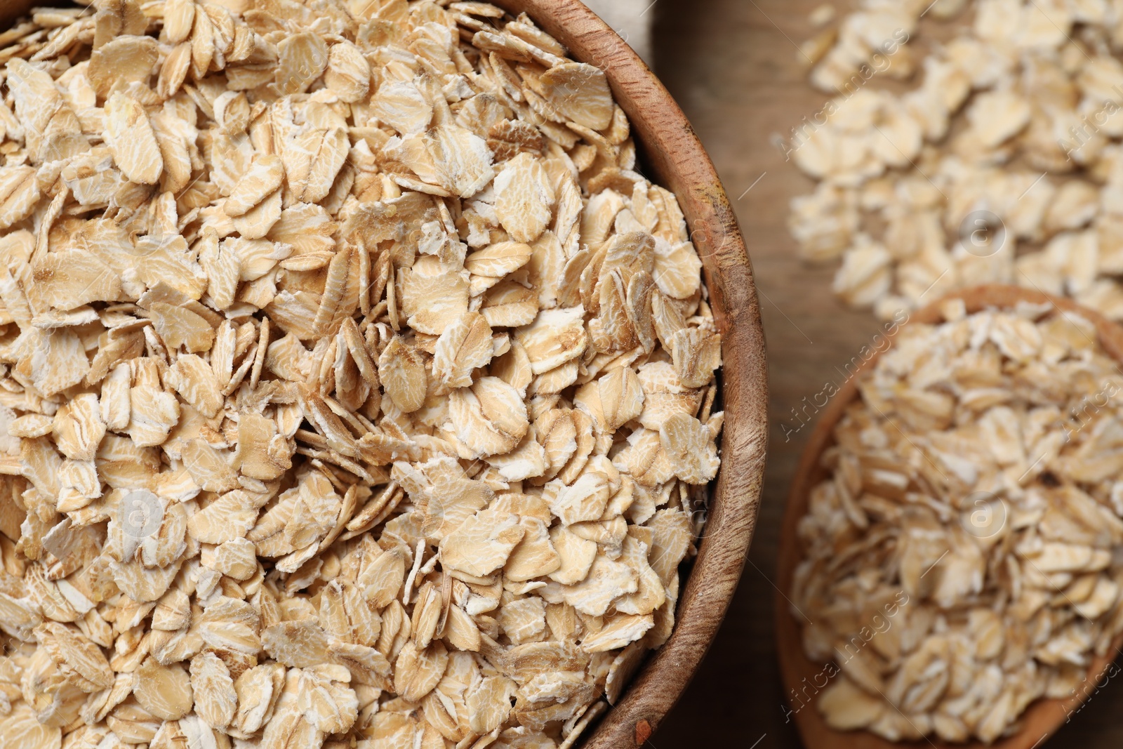 Photo of Bowl and spoon with oatmeal on table, top view. Space for text