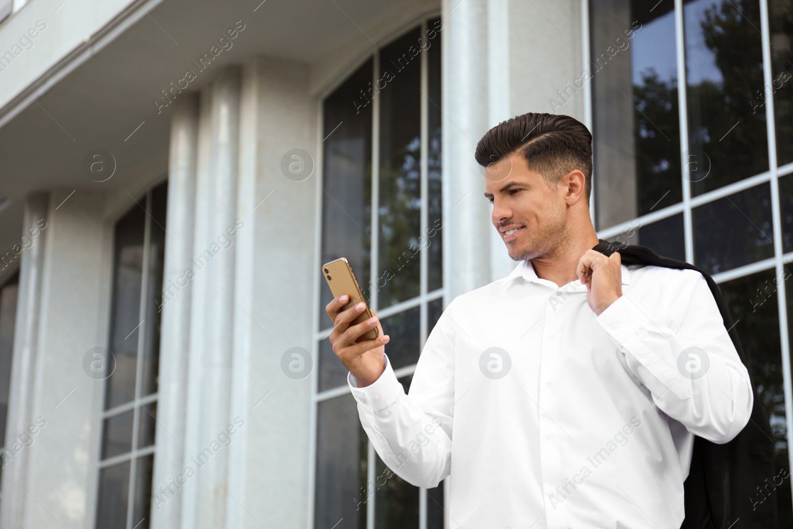 Photo of Handsome man with smartphone on city street