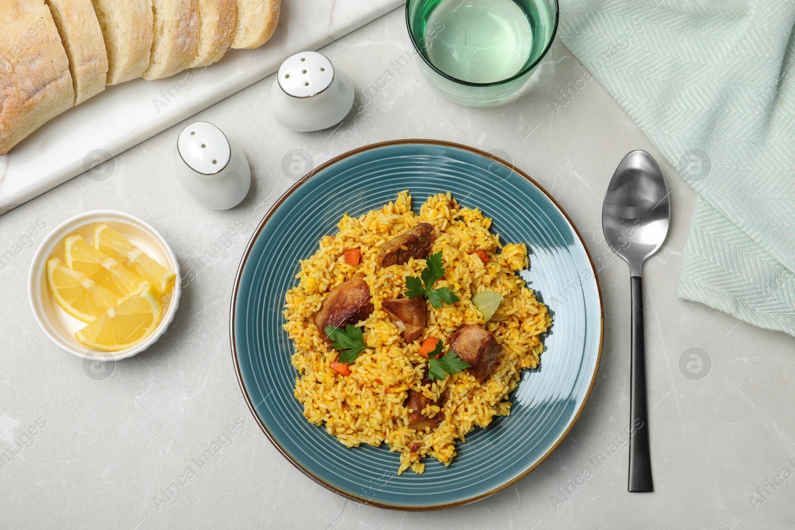 Photo of Delicious rice pilaf served on table, flat lay