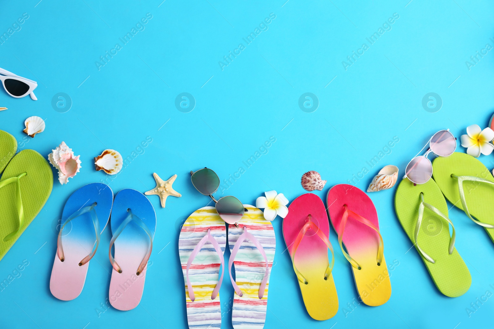 Photo of Flat lay composition with different flip flops on blue background, space for text. Summer beach accessories