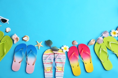 Flat lay composition with different flip flops on blue background, space for text. Summer beach accessories