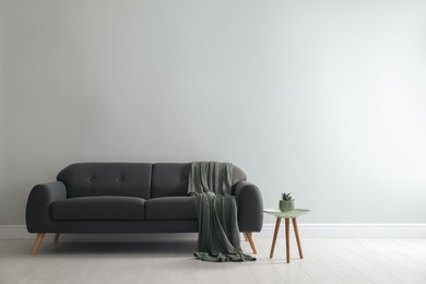 Photo of Stylish living room interior with comfortable grey sofa and beautiful plant