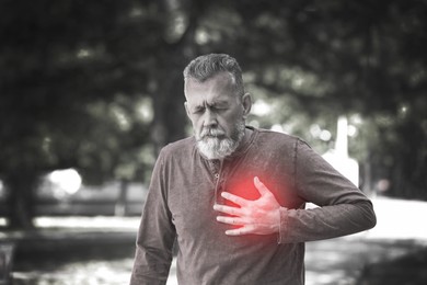 Image of Mature man having heart attack in park