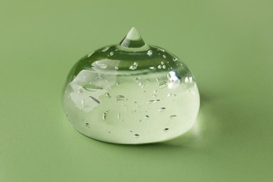 Photo of Sample of clear cosmetic gel on light green background, closeup