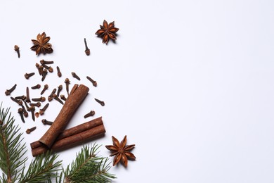 Photo of Different spices and fir branches on white table, flat lay. Space for text