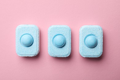 Photo of Water softener tablets on pink background, flat lay