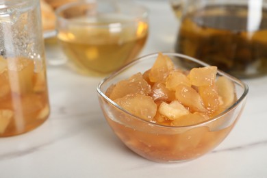Photo of Delicious apple jam in bowl on white table, closeup