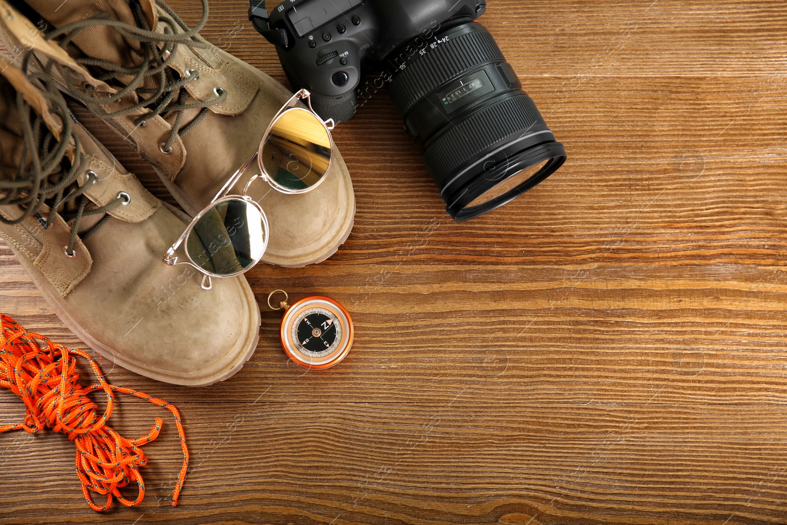 Photo of Flat lay composition with camping equipment on wooden background