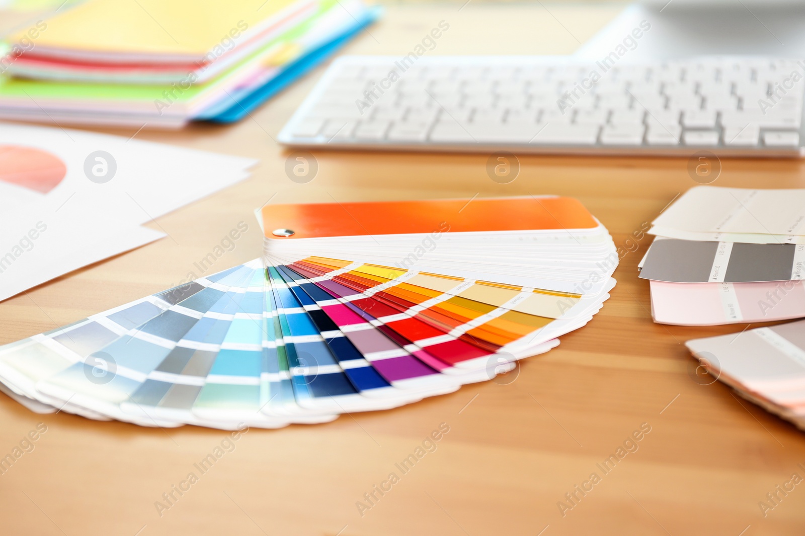 Photo of Paint color palette samples on wooden table, closeup