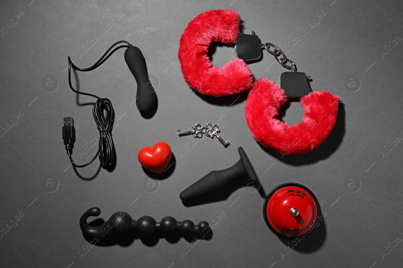 Photo of Different sex toys on dark background, flat lay