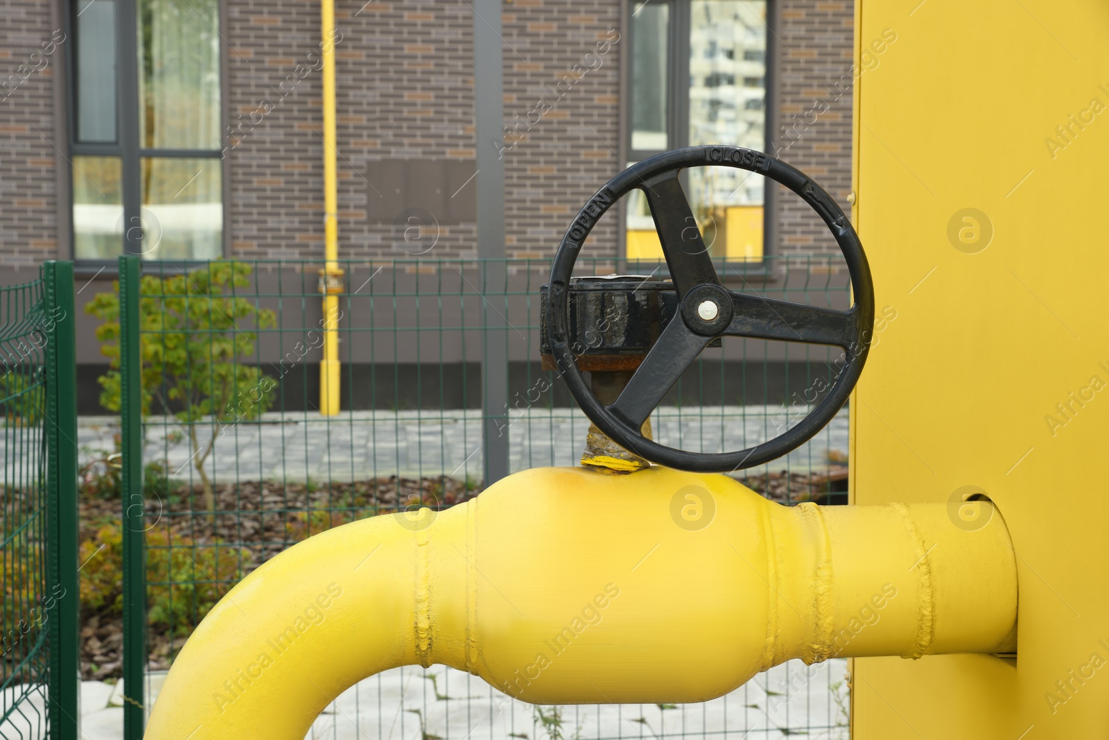 Photo of Black flywheel on yellow gas pipe outdoors