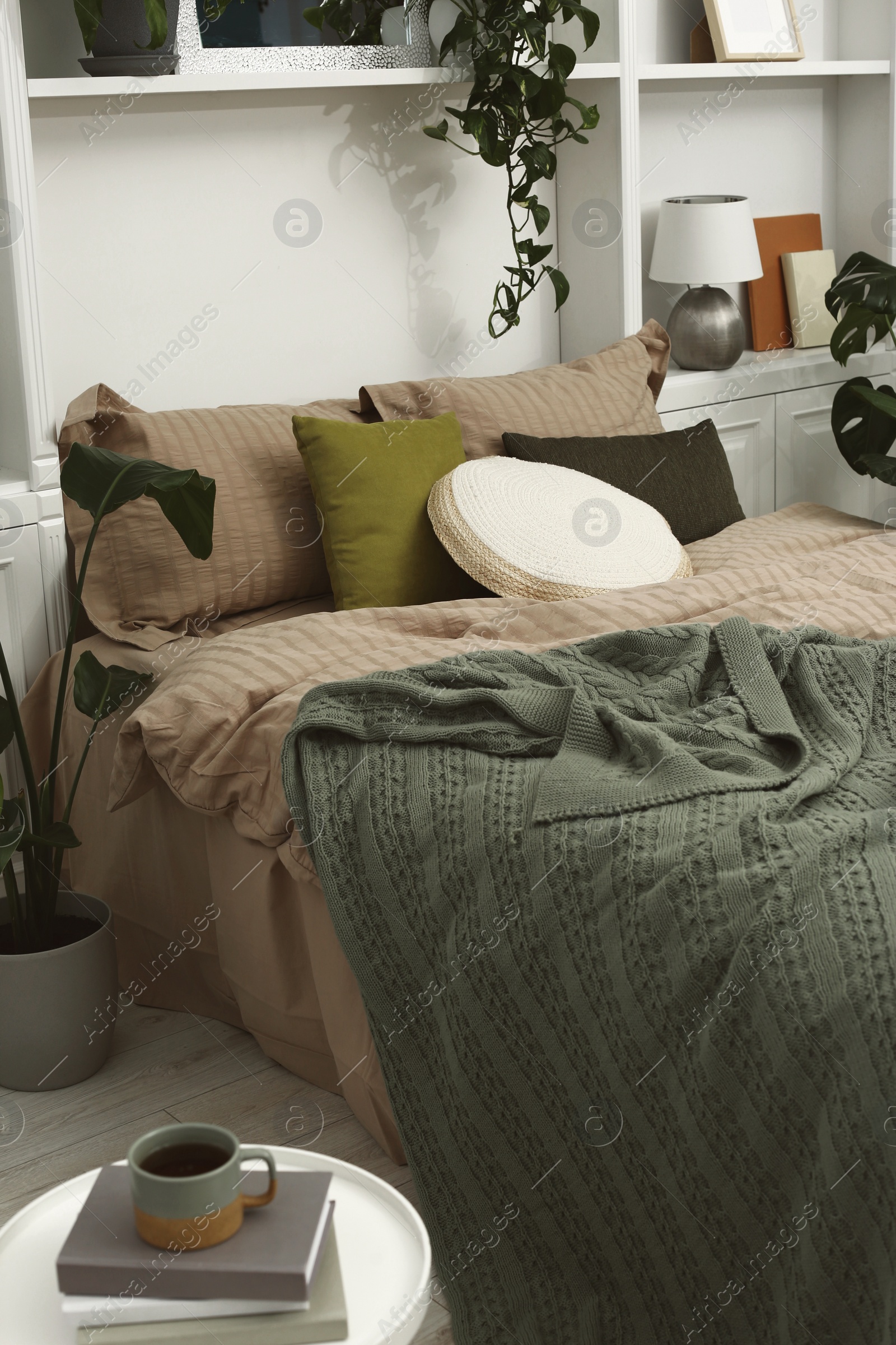 Photo of Comfortable bed and different houseplants in bedroom. Interior design