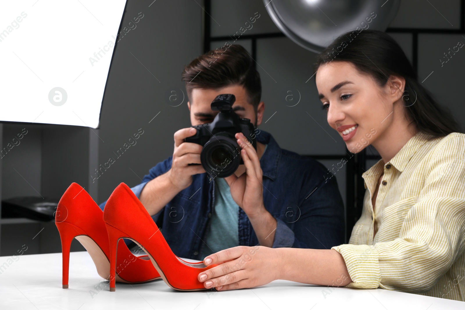 Photo of Professional photographers shooting stylish shoes in studio