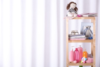 Photo of Set with baby accessories on shelving unit against light background, space for text