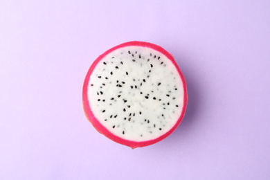 Photo of Slice of delicious dragon fruit (pitahaya) on violet background, top view