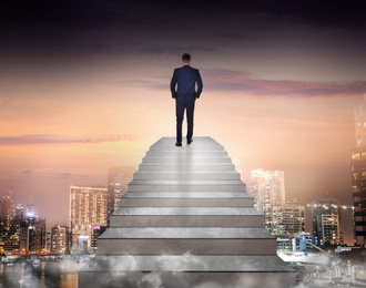 Image of Man standing on top of stairs and looking at cityscape. Way to success