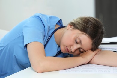 Exhausted doctor sleeping at workplace in hospital