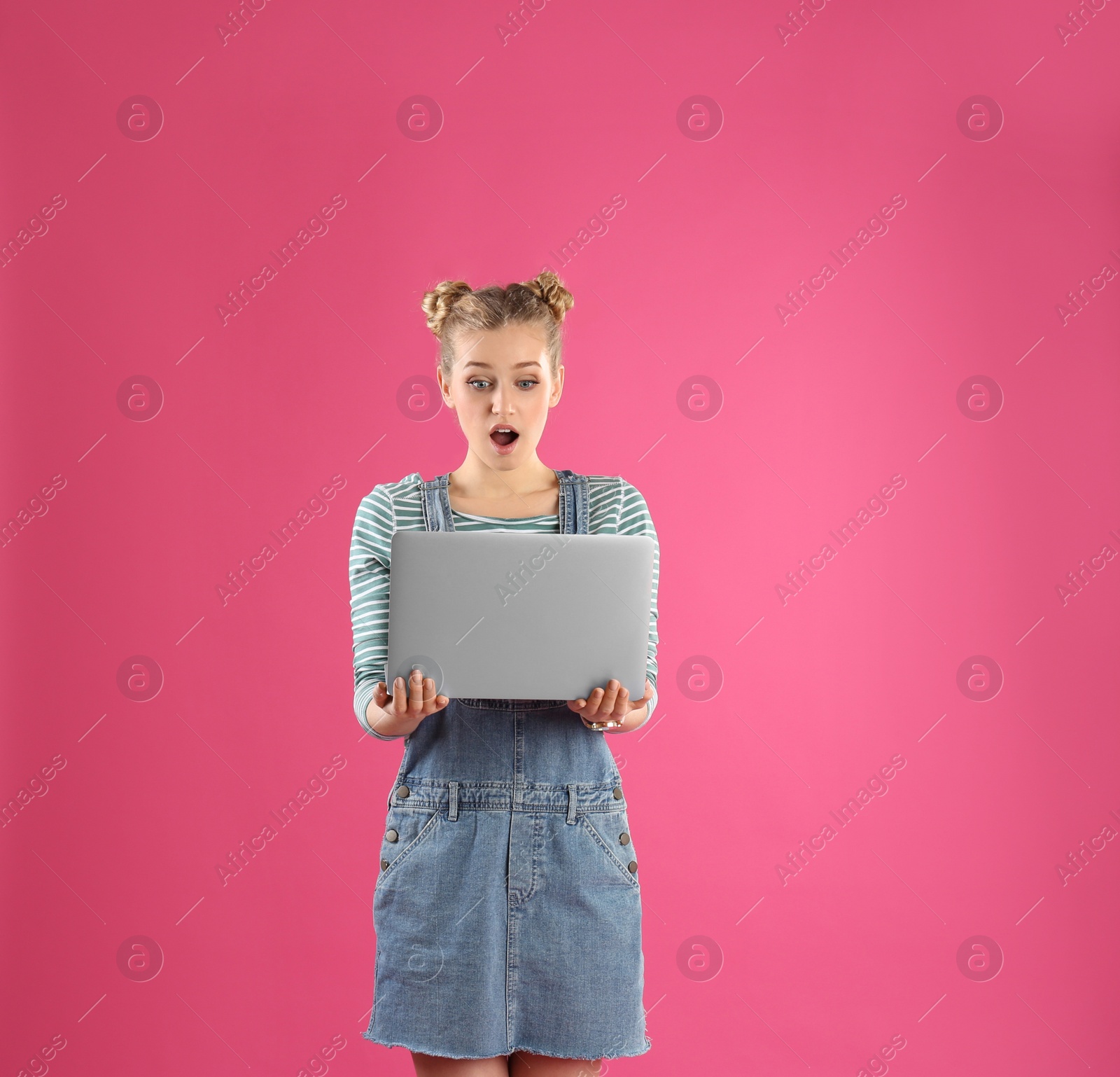 Photo of Portrait of young woman with laptop on pink background