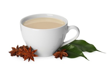 Cup of tea with milk, anise stars and green leaves on white background