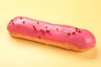 Delicious eclair covered with glaze on yellow background