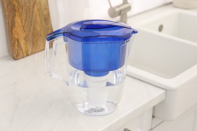 Water filter jug on white countertop in kitchen