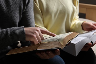 Photo of Couple reading Bibles in room, closeup view