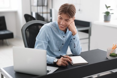 Man watching webinar at table in office