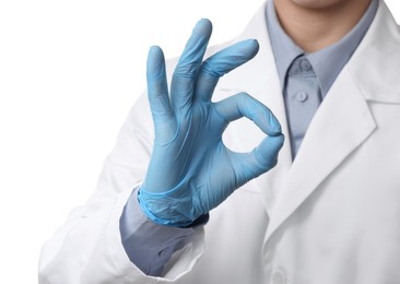 Doctor wearing light blue medical gloves showing ok gesture on white background, closeup