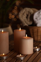 Spa composition with burning candles on wooden table