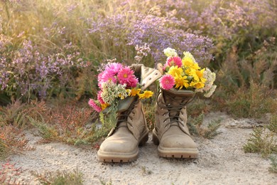 Photo of Boots with beautiful wild flowers in meadow