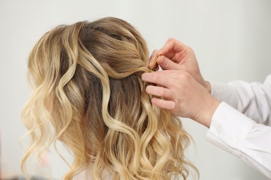 Photo of Hair styling. Professional hairdresser working with client indoors, closeup