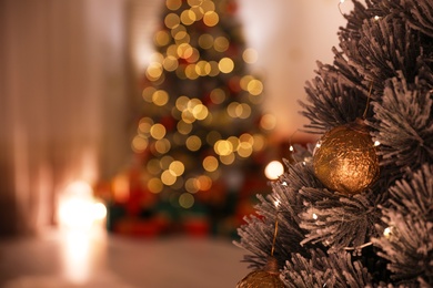 Beautiful Christmas tree decorated with ball in stylish room interior, closeup. Space for text