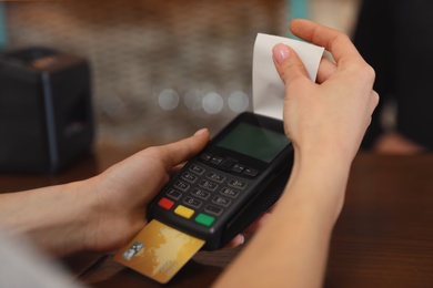 Photo of Woman using credit card machine for non cash payment in cafe, closeup. Space for text