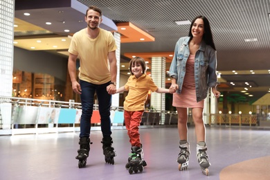 Happy family spending time at roller skating rink