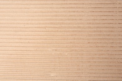 Photo of Texture of beige corrugated paper sheet as background, closeup