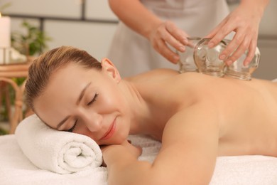 Photo of Therapist giving cupping treatment to patient in spa salon