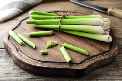 Fresh lemongrass, knife and cutting board on wooden table