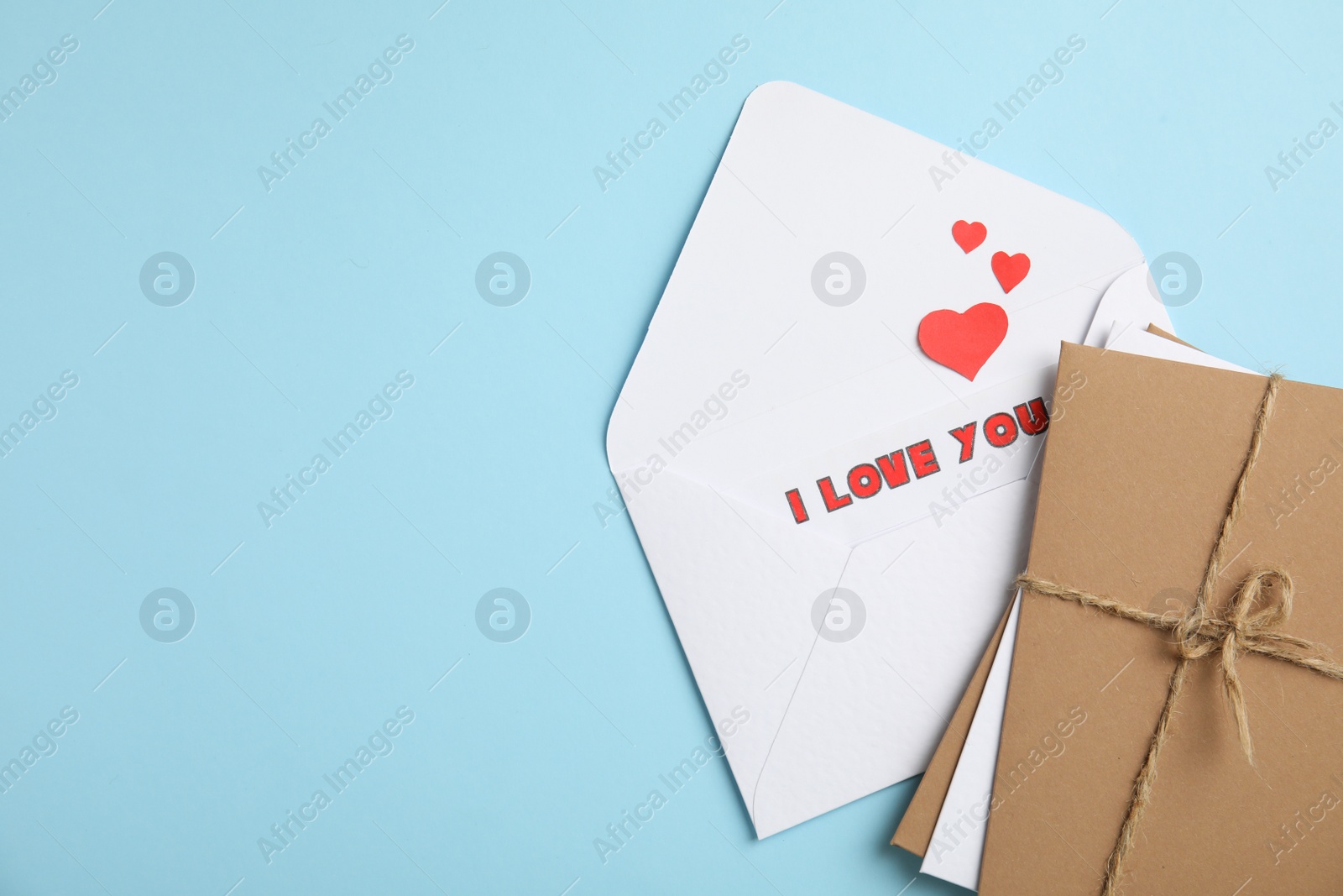 Photo of Love letter and stack of envelopes on light blue background, flat lay. Space for text