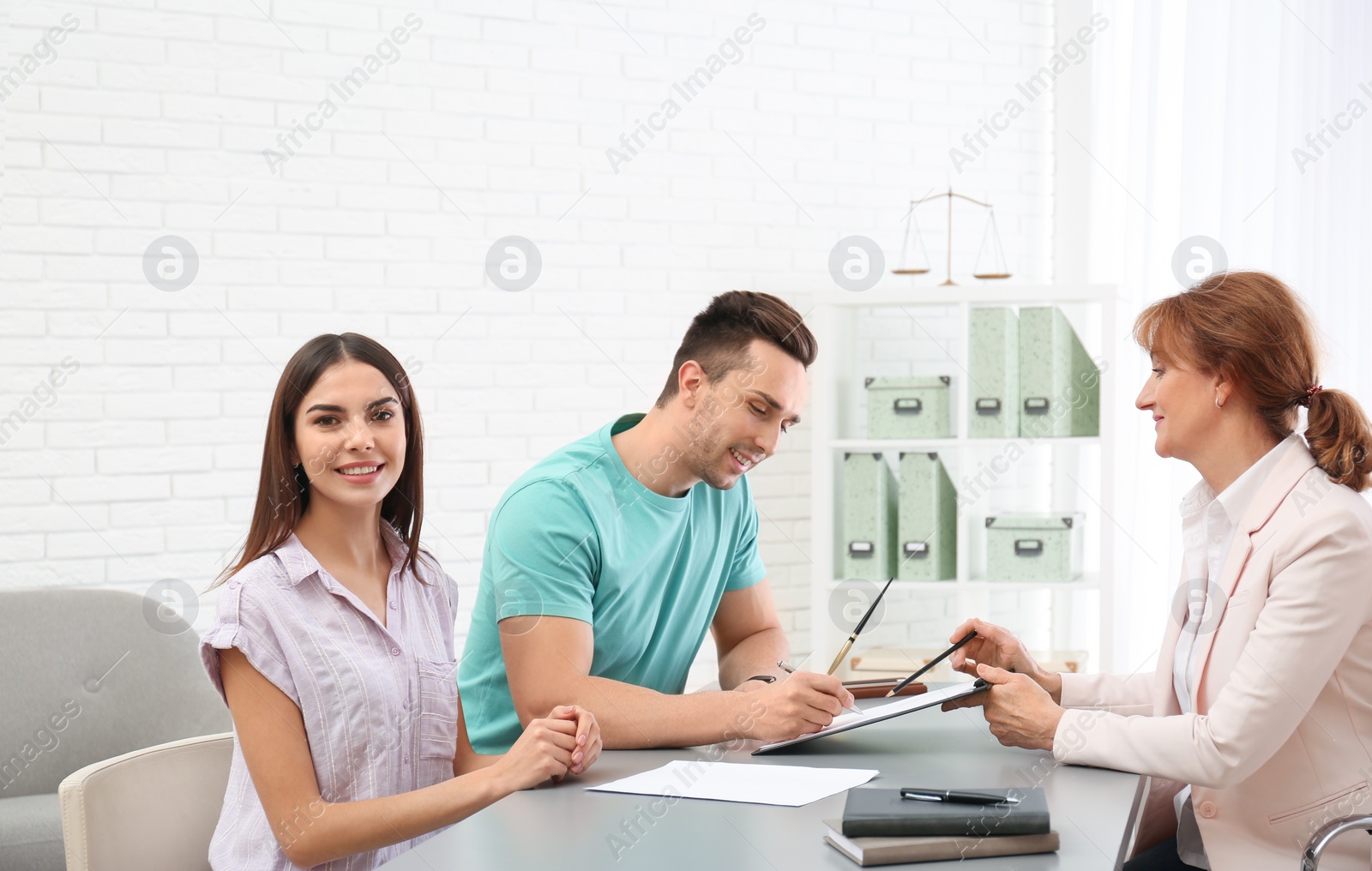 Photo of Lawyer having meeting with young couple in office