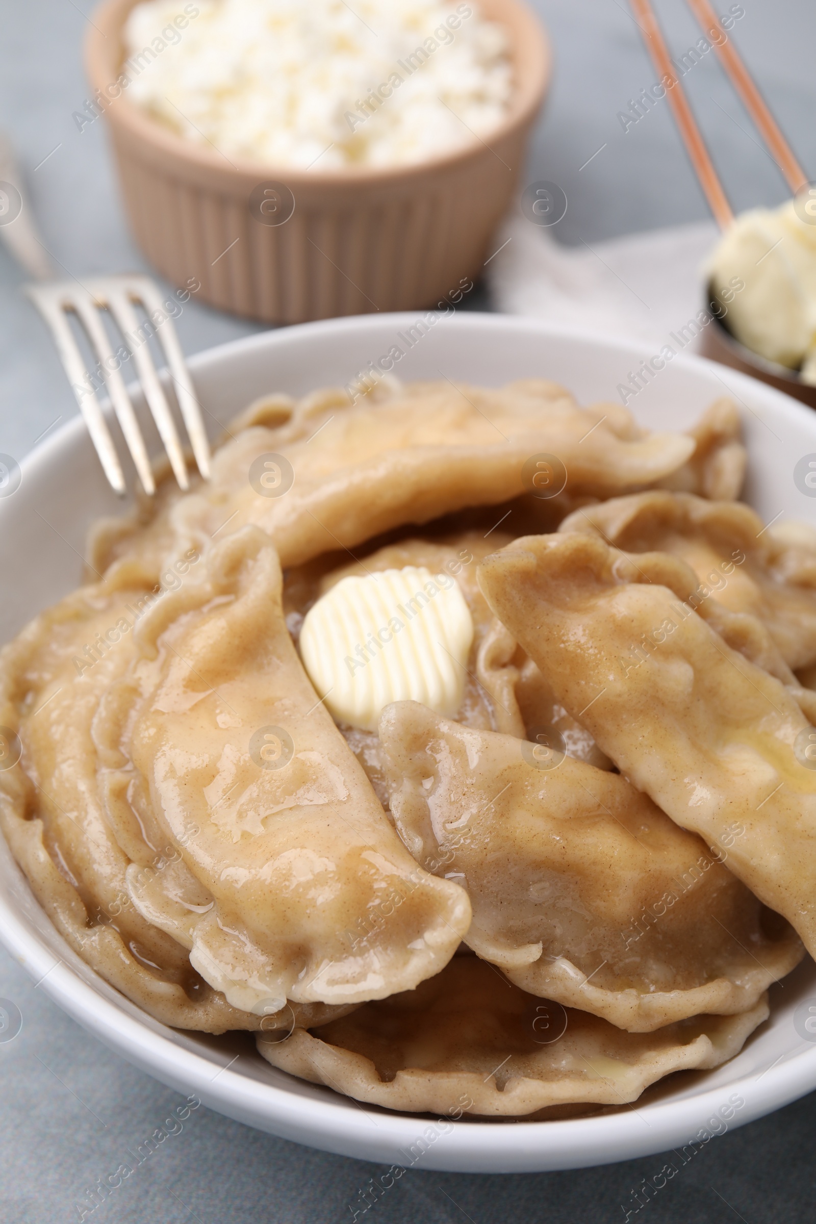 Photo of Delicious dumplings (varenyky) with cottage cheese and butter served on table, closeup