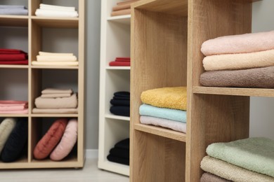 Photo of Different colorful bed linens and towels on display in home textiles store, closeup