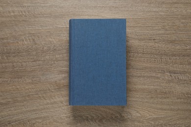 Photo of Closed hardcover book on wooden table, top view